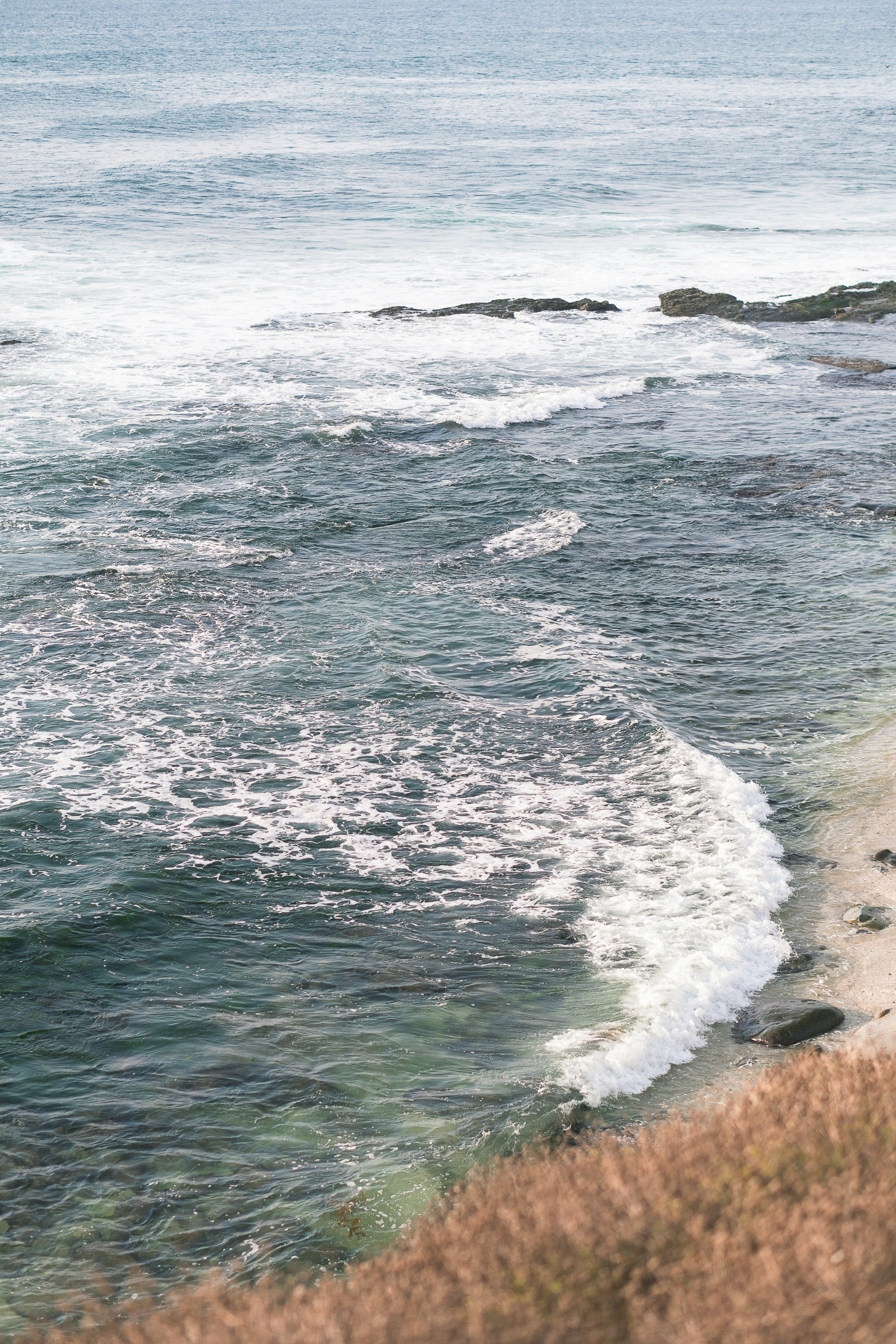 sea waves crashing on shore during daytime